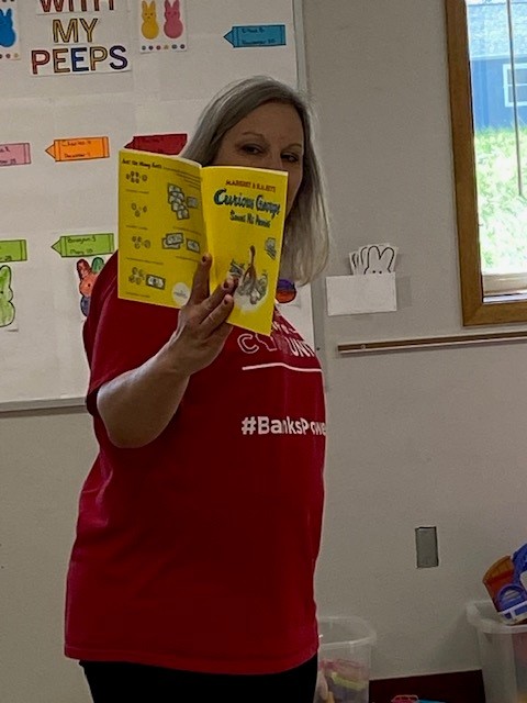 Adult reading in front of a classroom