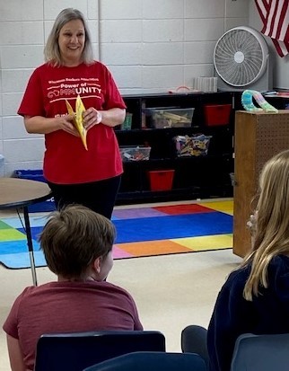 Adult preparing to read in front of a classroom